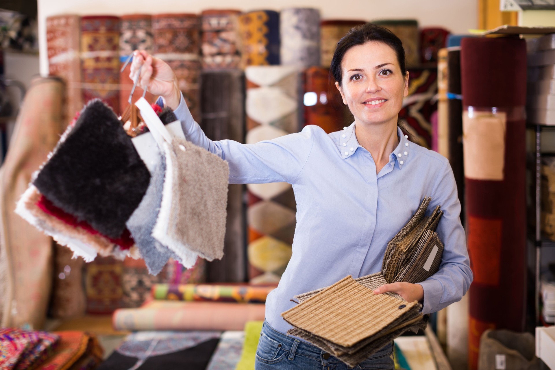 Glad woman shopping carpet and showing samples